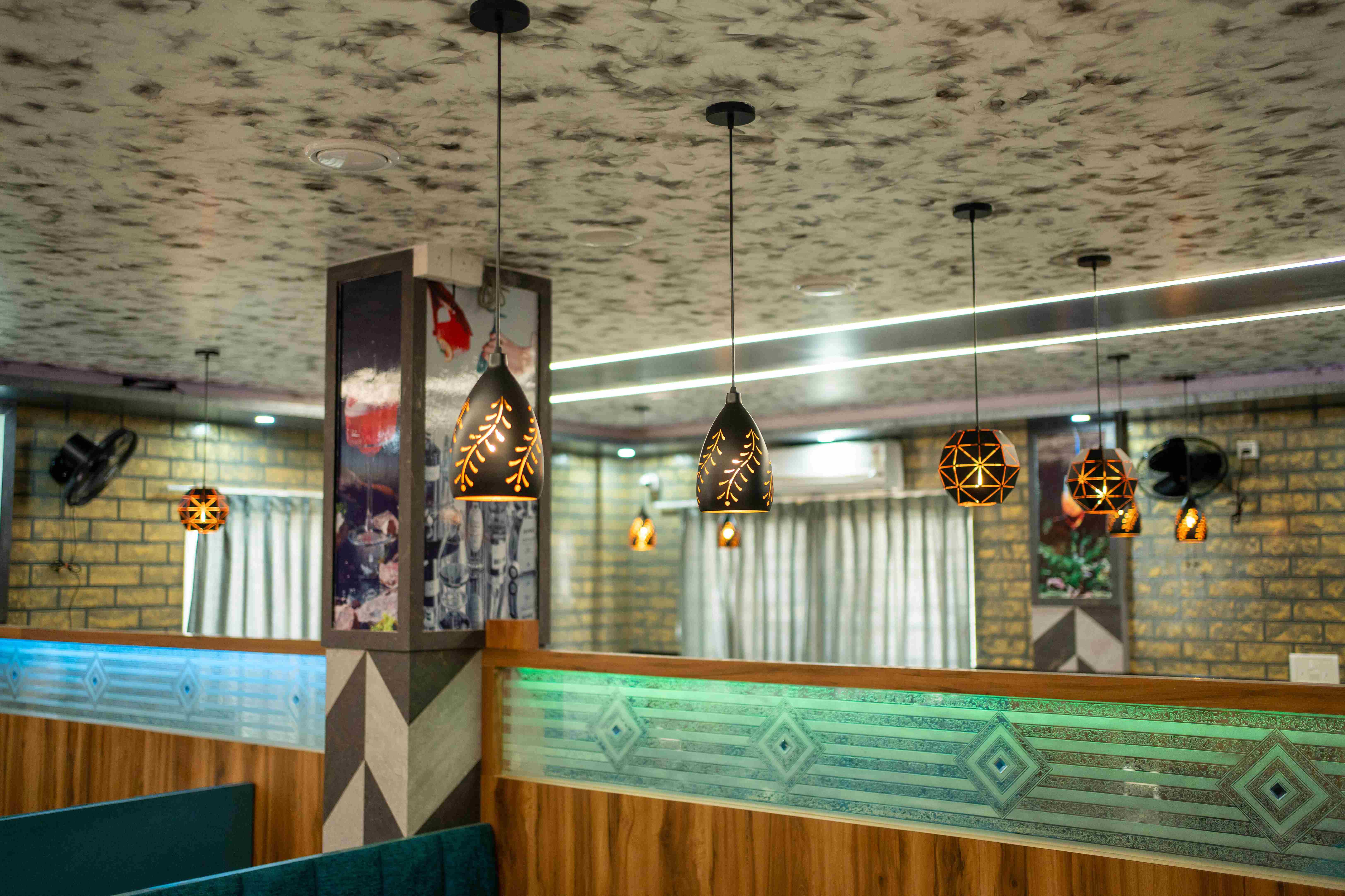 Elixir Hotel bar area with hanging lamps and modern decor