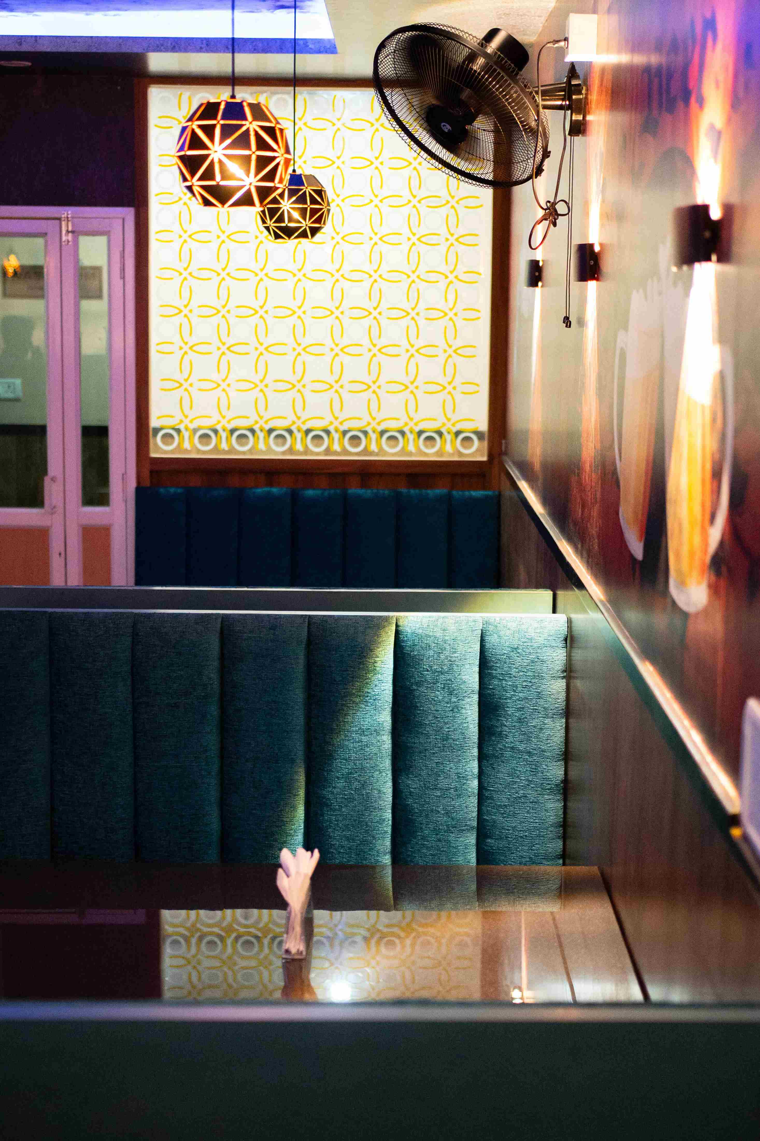 Elixir Hotel cozy seating area with patterned wall and hanging lamps